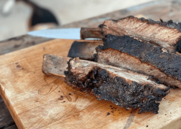 Grilled beef short ribs on a cutting board.